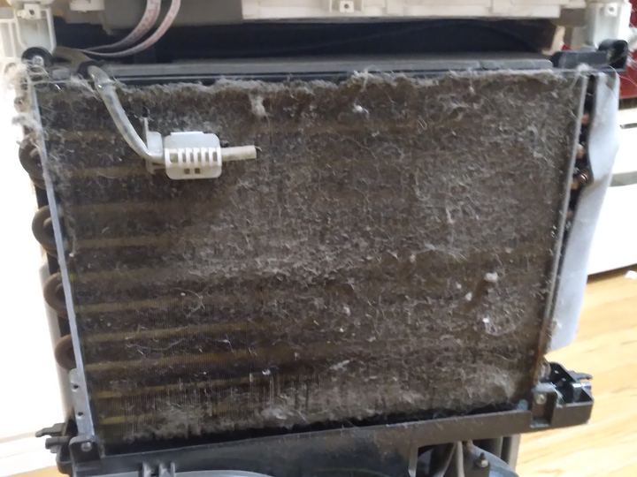 A dust-clogged air conditioner filter screen