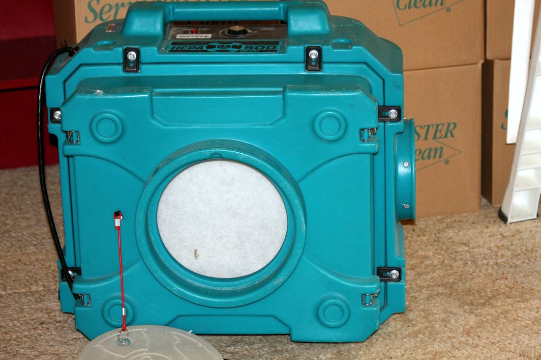 A portable HEPA air filtration unit with a round filter window